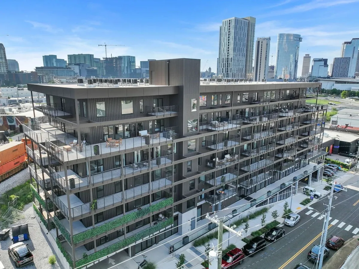 A sweeping view of Hyve’s modern exterior, showcasing balconies, rooftop amenities, and the vibrant urban landscape. The image emphasizes the building’s contemporary style and its integration with Nashville’s city life.