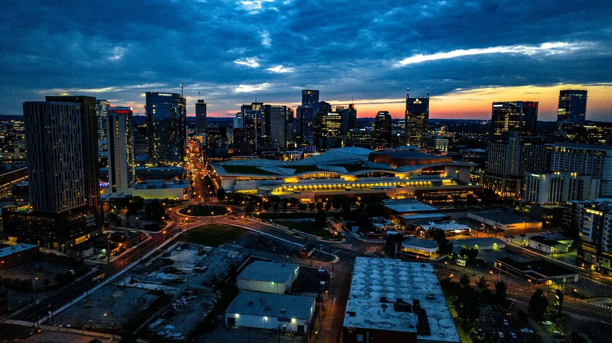A captivating city skyline at dusk, with illuminated buildings and lively streets below. The view captures both the excitement and energy of downtown Nashville, suggesting endless opportunities for after-work exploration.