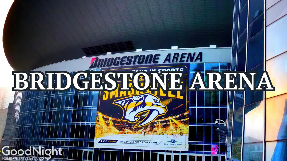 A dynamic exterior view of Bridgestone Arena, featuring its modern architecture and the prominent Nashville Predators banner. The arena is set against a bustling city backdrop, emphasizing its role as a major downtown destination.